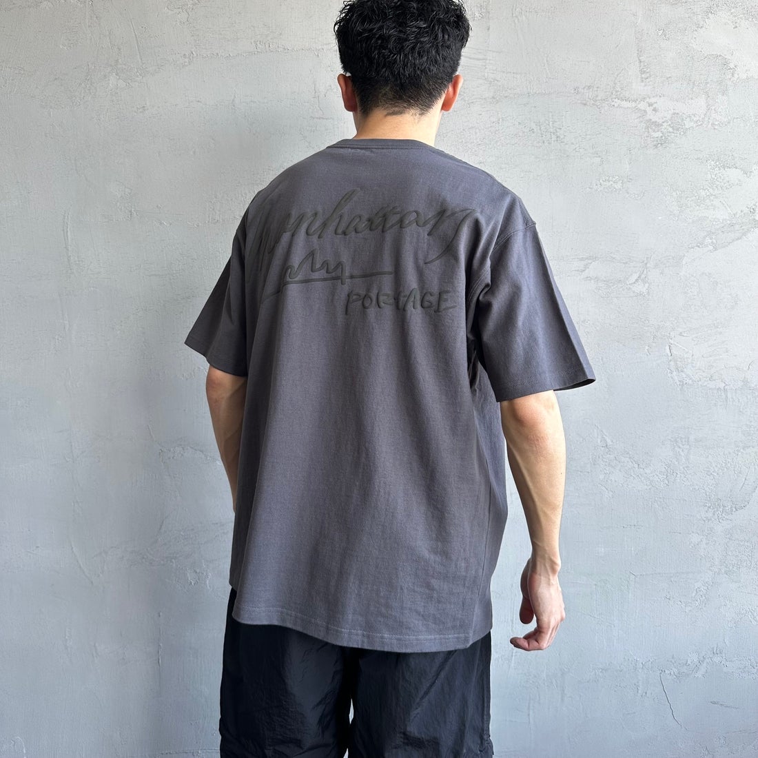 MANHATTAN PORTAGE [マンハッタンポーテージ] 別注 手描き風ロゴ バックプリントTシャツ [25SSMP-IN63-JF] CHARCOAL &&モデル身長：168cm 着用サイズ：L&&
