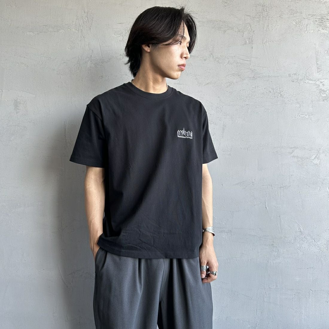 MANHATTAN PORTAGE [マンハッタンポーテージ] 別注 ランダムロゴ バックプリントTシャツ [25SSMP-IN66-JF] BLACK &&モデル身長：179cm 着用サイズ：L&&