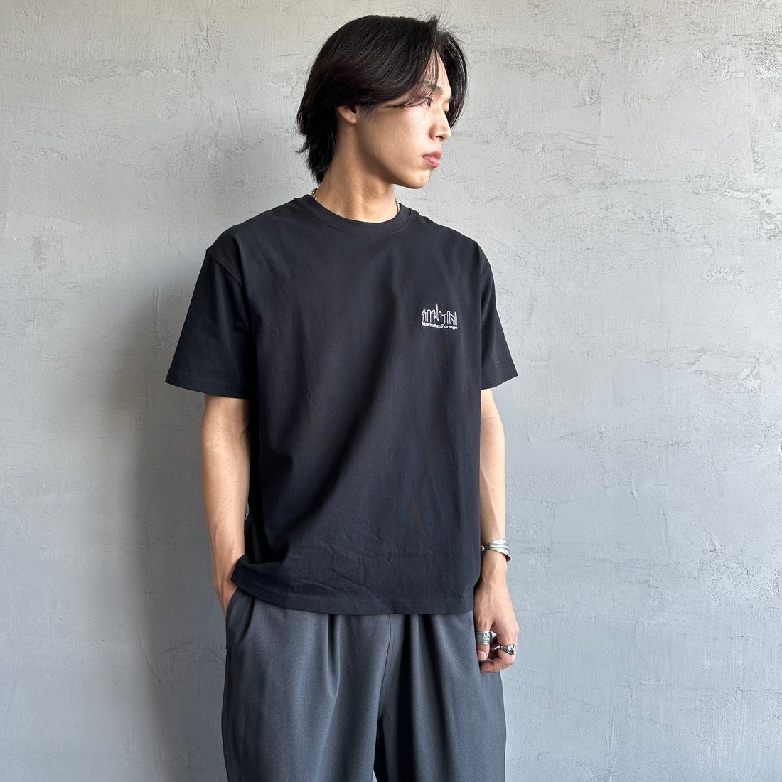 MANHATTAN PORTAGE [マンハッタンポーテージ] 別注 ランダムロゴ バックプリントTシャツ [25SSMP-IN66-JF] BLACK &&モデル身長：179cm 着用サイズ：L&&