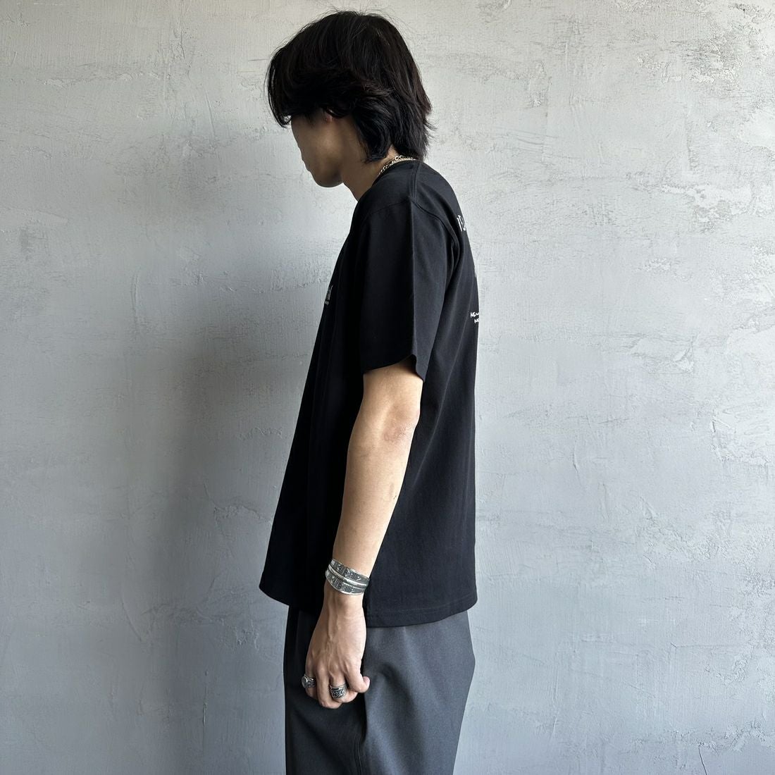 MANHATTAN PORTAGE [マンハッタンポーテージ] 別注 ランダムロゴ バックプリントTシャツ [25SSMP-IN66-JF] BLACK &&モデル身長：179cm 着用サイズ：L&&