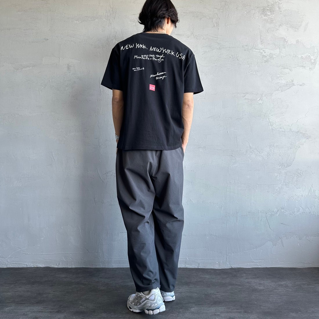MANHATTAN PORTAGE [マンハッタンポーテージ] 別注 ランダムロゴ バックプリントTシャツ [25SSMP-IN66-JF] BLACK &&モデル身長：179cm 着用サイズ：L&&