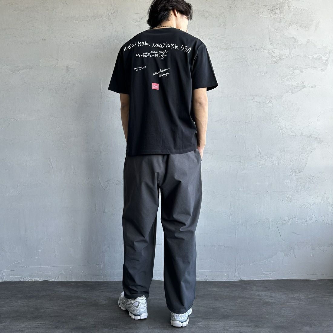 MANHATTAN PORTAGE [マンハッタンポーテージ] 別注 ランダムロゴ バックプリントTシャツ [25SSMP-IN66-JF] BLACK &&モデル身長：179cm 着用サイズ：L&&