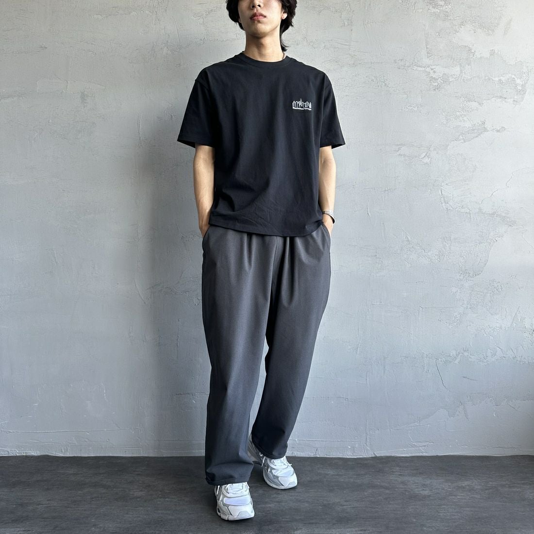 MANHATTAN PORTAGE [マンハッタンポーテージ] 別注 ランダムロゴ バックプリントTシャツ [25SSMP-IN66-JF] BLACK &&モデル身長：179cm 着用サイズ：L&&