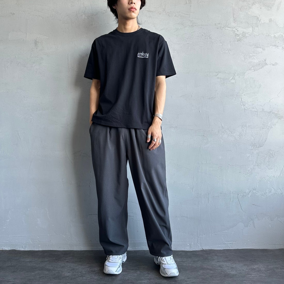 MANHATTAN PORTAGE [マンハッタンポーテージ] 別注 ランダムロゴ バックプリントTシャツ [25SSMP-IN66-JF] BLACK &&モデル身長：179cm 着用サイズ：L&&