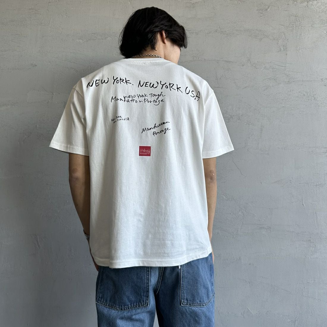MANHATTAN PORTAGE [マンハッタンポーテージ] 別注 ランダムロゴ バックプリントTシャツ [25SSMP-IN66-JF] WHITE &&モデル身長：179cm 着用サイズ：L&&