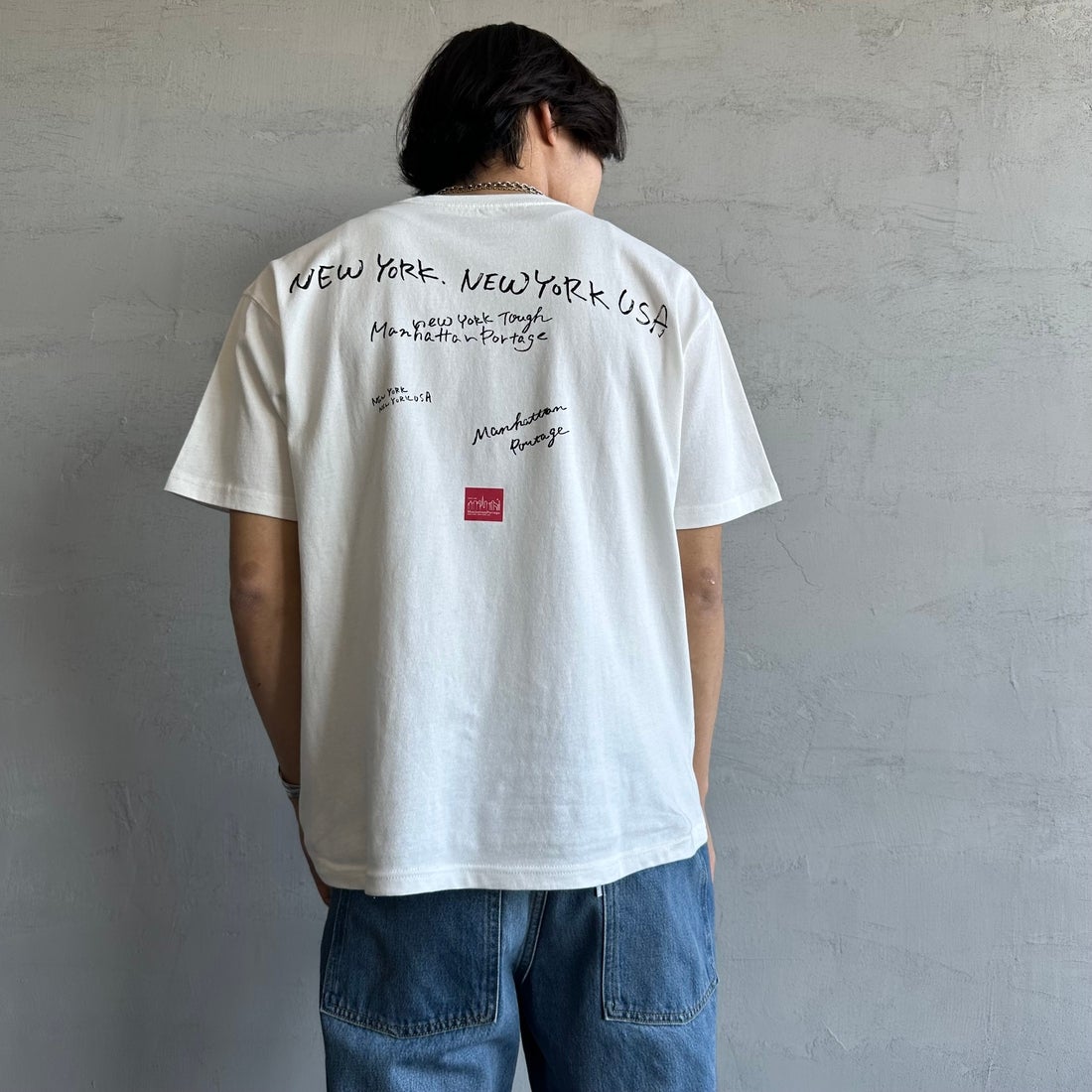 MANHATTAN PORTAGE [マンハッタンポーテージ] 別注 ランダムロゴ バックプリントTシャツ [25SSMP-IN66-JF] WHITE &&モデル身長：179cm 着用サイズ：L&&