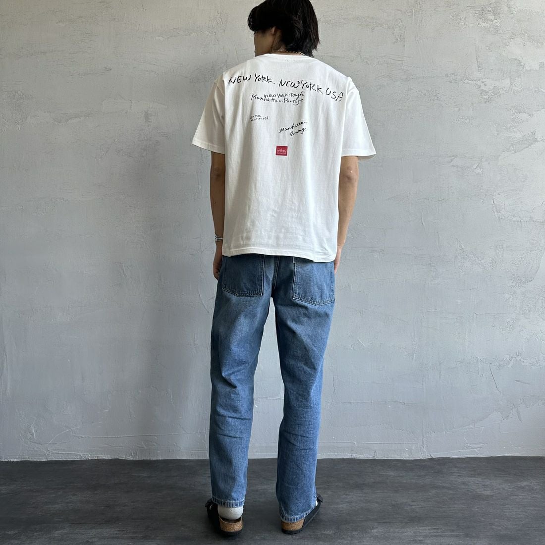 MANHATTAN PORTAGE [マンハッタンポーテージ] 別注 ランダムロゴ バックプリントTシャツ [25SSMP-IN66-JF] WHITE &&モデル身長：179cm 着用サイズ：L&&