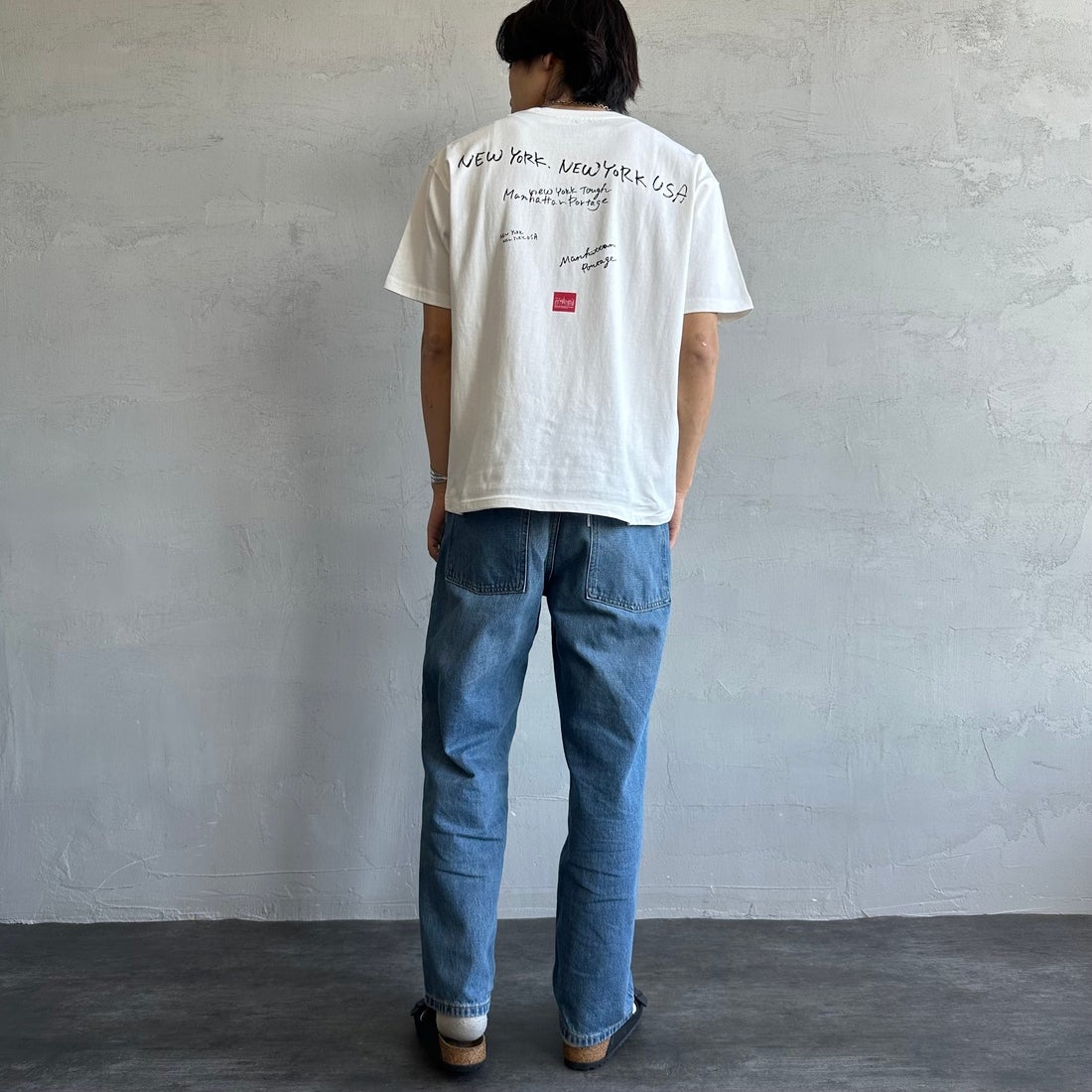 MANHATTAN PORTAGE [マンハッタンポーテージ] 別注 ランダムロゴ バックプリントTシャツ [25SSMP-IN66-JF] WHITE &&モデル身長：179cm 着用サイズ：L&&