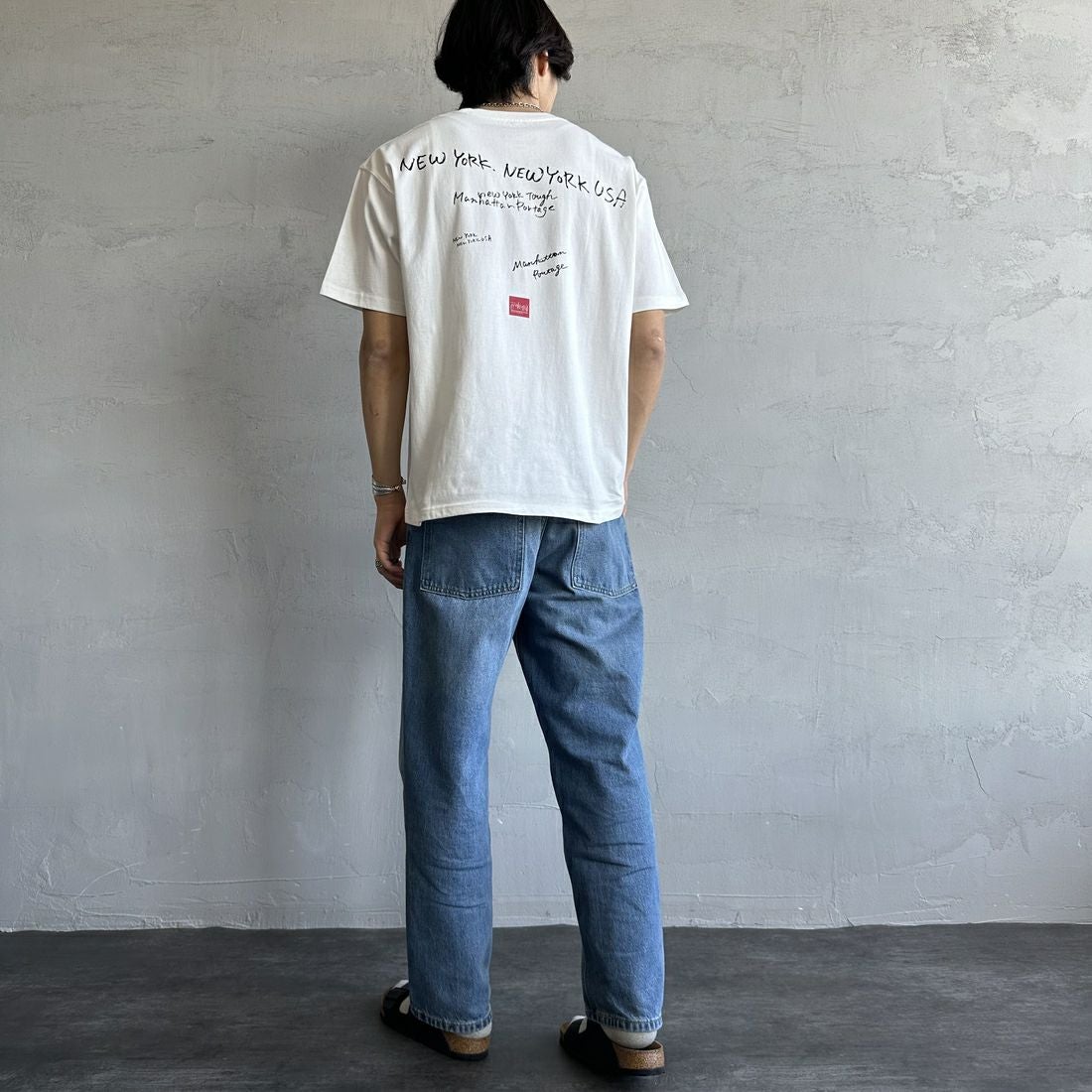 MANHATTAN PORTAGE [マンハッタンポーテージ] 別注 ランダムロゴ バックプリントTシャツ [25SSMP-IN66-JF] WHITE &&モデル身長：179cm 着用サイズ：L&&