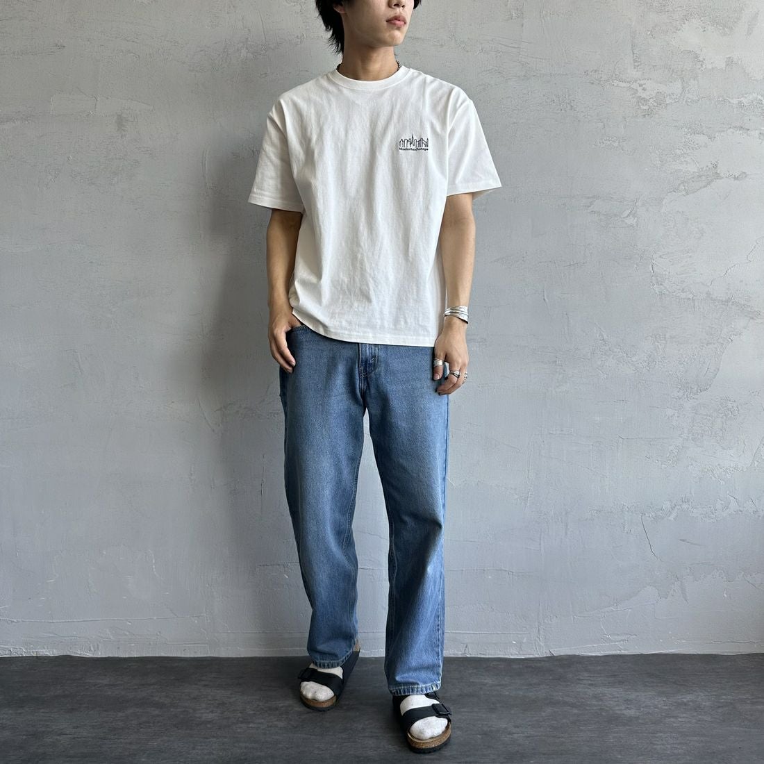 MANHATTAN PORTAGE [マンハッタンポーテージ] 別注 ランダムロゴ バックプリントTシャツ [25SSMP-IN66-JF] WHITE &&モデル身長：179cm 着用サイズ：L&&