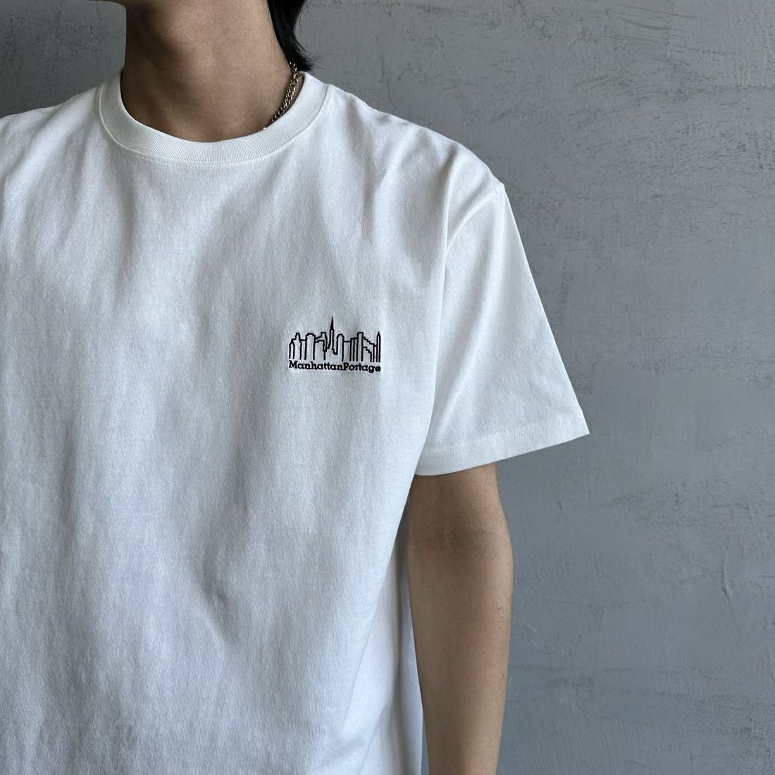 MANHATTAN PORTAGE [マンハッタンポーテージ] 別注 ランダムロゴ バックプリントTシャツ [25SSMP-IN66-JF] WHITE &&モデル身長：179cm 着用サイズ：L&&