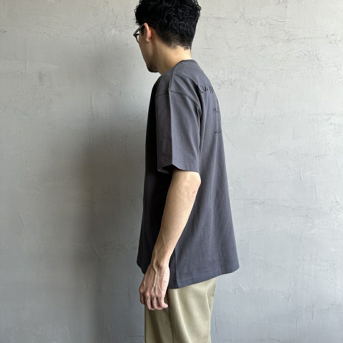 MANHATTAN PORTAGE [マンハッタンポーテージ] 別注 ランダムロゴ バックプリントTシャツ [25SSMP-IN66-JF] CHARCOAL &&モデル身長：168cm 着用サイズ：L&&
