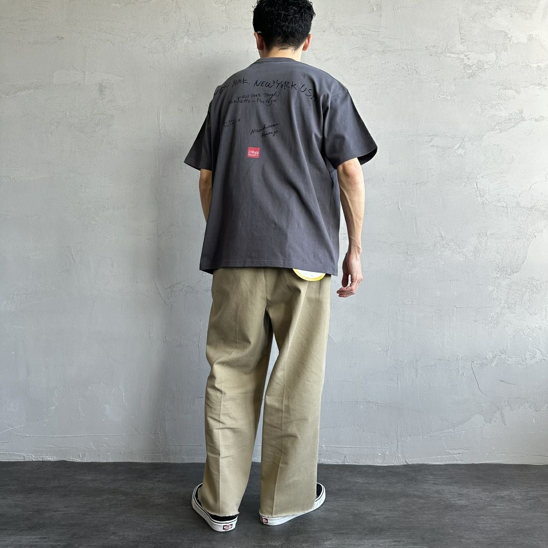 MANHATTAN PORTAGE [マンハッタンポーテージ] 別注 ランダムロゴ バックプリントTシャツ [25SSMP-IN66-JF] CHARCOAL &&モデル身長：168cm 着用サイズ：L&&