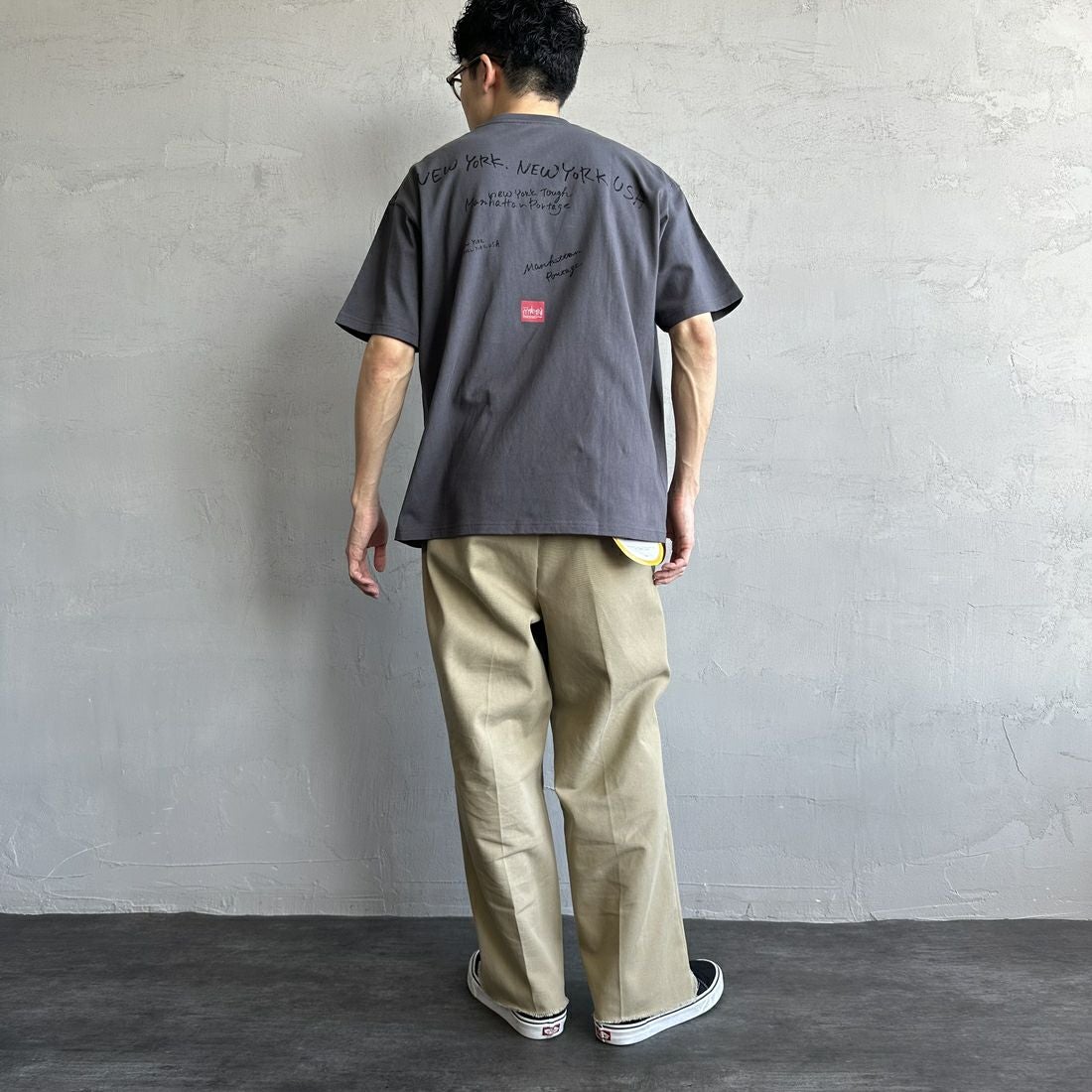 MANHATTAN PORTAGE [マンハッタンポーテージ] 別注 ランダムロゴ バックプリントTシャツ [25SSMP-IN66-JF] CHARCOAL &&モデル身長：168cm 着用サイズ：L&&