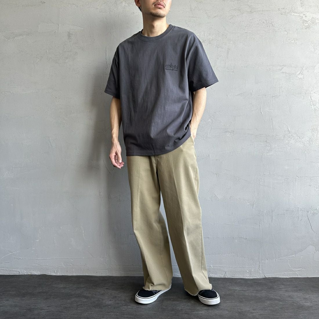 MANHATTAN PORTAGE [マンハッタンポーテージ] 別注 ランダムロゴ バックプリントTシャツ [25SSMP-IN66-JF] CHARCOAL &&モデル身長：168cm 着用サイズ：L&&