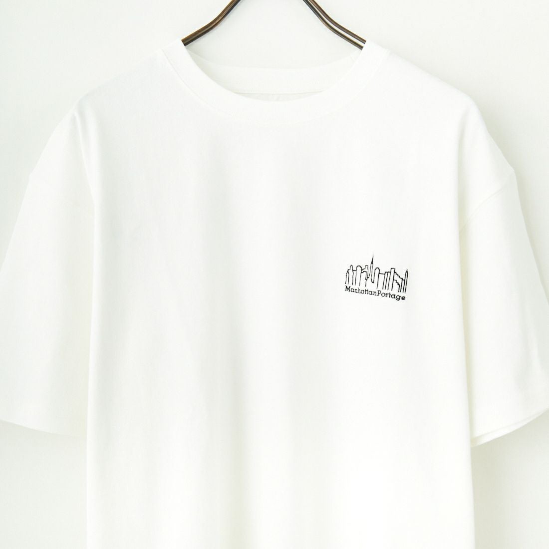 MANHATTAN PORTAGE [マンハッタンポーテージ] 別注 ランダムロゴ バックプリントTシャツ [25SSMP-IN66-JF] WHITE