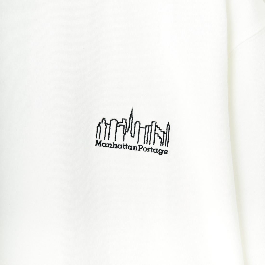 MANHATTAN PORTAGE [マンハッタンポーテージ] 別注 ランダムロゴ バックプリントTシャツ [25SSMP-IN66-JF] WHITE