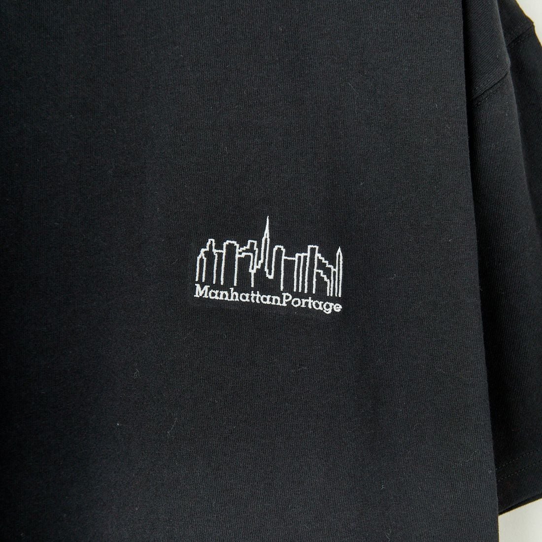 MANHATTAN PORTAGE [マンハッタンポーテージ] 別注 ランダムロゴ バックプリントTシャツ [25SSMP-IN66-JF] BLACK
