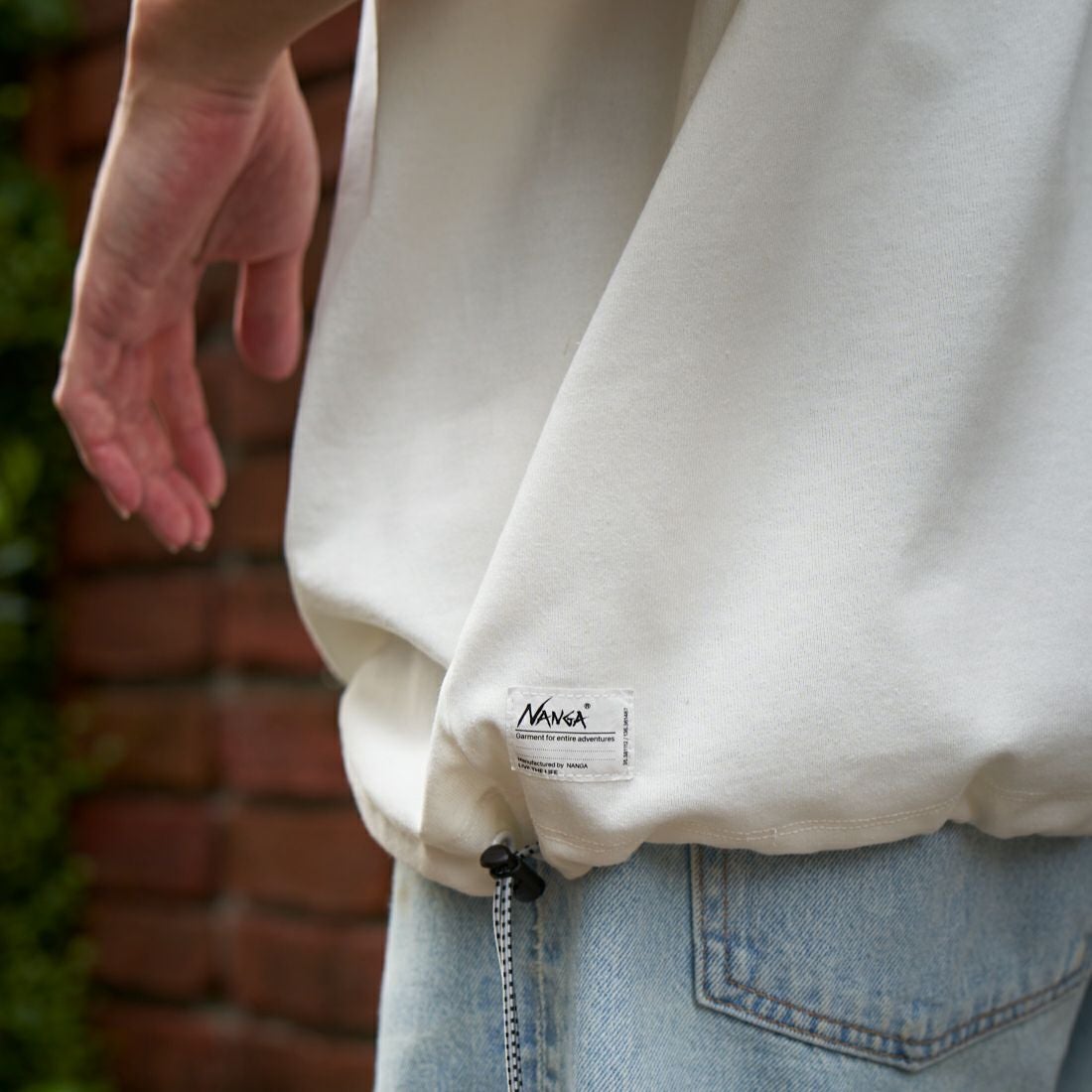 JEANSFACTORY × NANGA [ジーンズファクトリー × ナンガ] 別注 ワンポイントロゴ刺繍 ルーズフィットドローコードTシャツ [NW25SS-JF4] WHITE