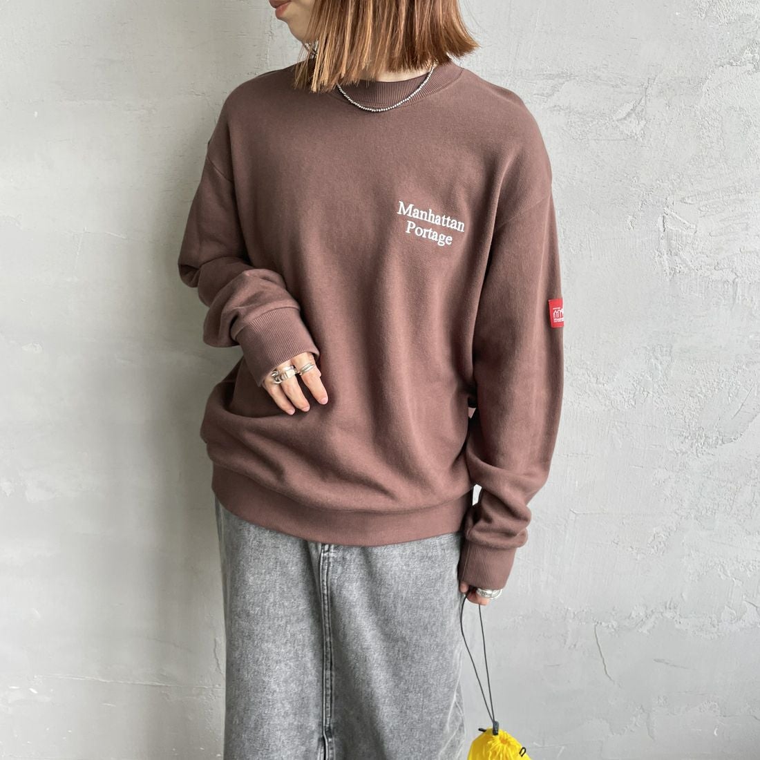 MANHATTAN PORTAGE [マンハッタンポーテージ] 別注 手書き風バック刺繍クルーネックスウェット [25FWMP-IN69-JF] D.BROWN &&モデル身長：158cm 着用サイズ：S&&