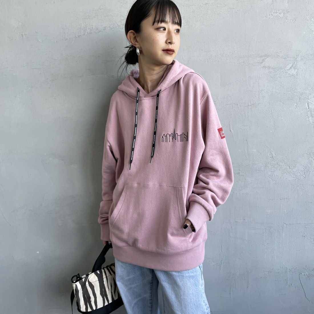 MANHATTAN PORTAGE [マンハッタンポーテージ] 別注 フードロゴ刺繍 スウェットパーカー [25FWMP-IN71-JF] PINK &&モデル身長：150cm 着用サイズ：S&&