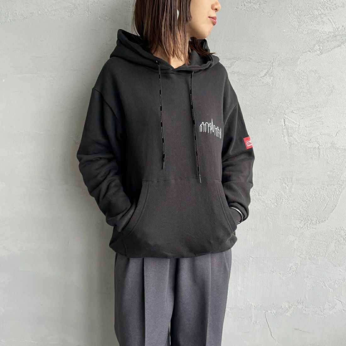 MANHATTAN PORTAGE [マンハッタンポーテージ] 別注 フードロゴ刺繍 スウェットパーカー [25FWMP-IN71-JF] BLACK &&モデル身長：159cm 着用サイズ：S&&