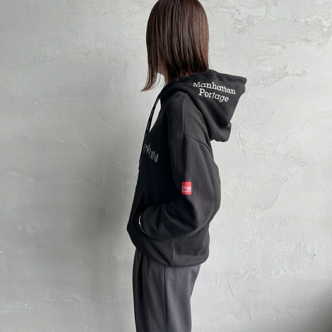 MANHATTAN PORTAGE [マンハッタンポーテージ] 別注 フードロゴ刺繍 スウェットパーカー [25FWMP-IN71-JF] BLACK &&モデル身長：159cm 着用サイズ：S&&