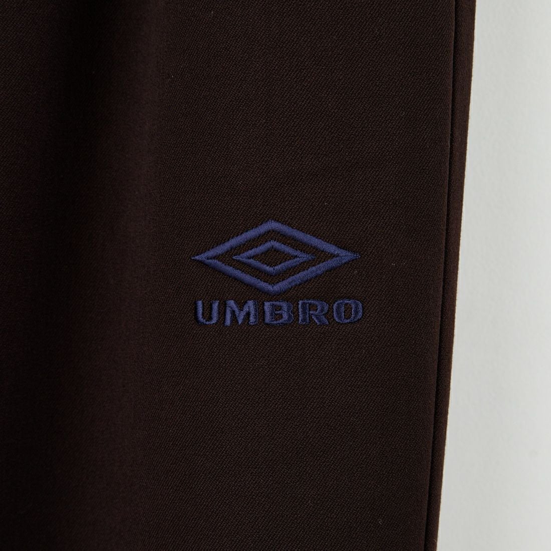 UMBRO [アンブロ] 別注 ワンポイント刺繍ロゴ トラックパンツ [KBT126-NK-PT2-MS-JF] BROWN