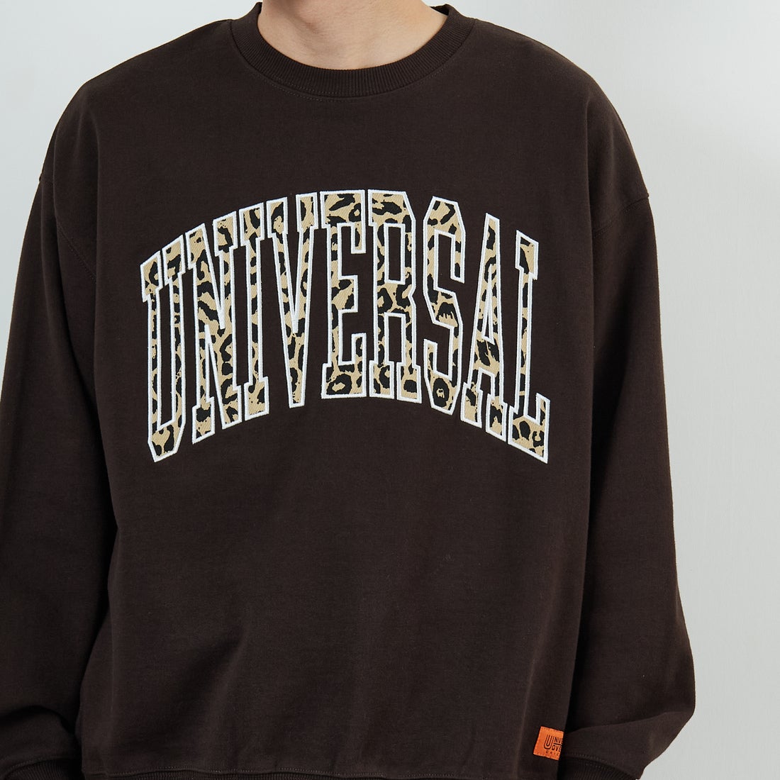 UNIVERSAL OVERALL [ユニバーサルオーバーオール] 別注 カレッジロゴデザイン クルーネックスウェット [U2531228IN-JF] BROWN &&モデル身長：168cm 着用サイズ：M&&