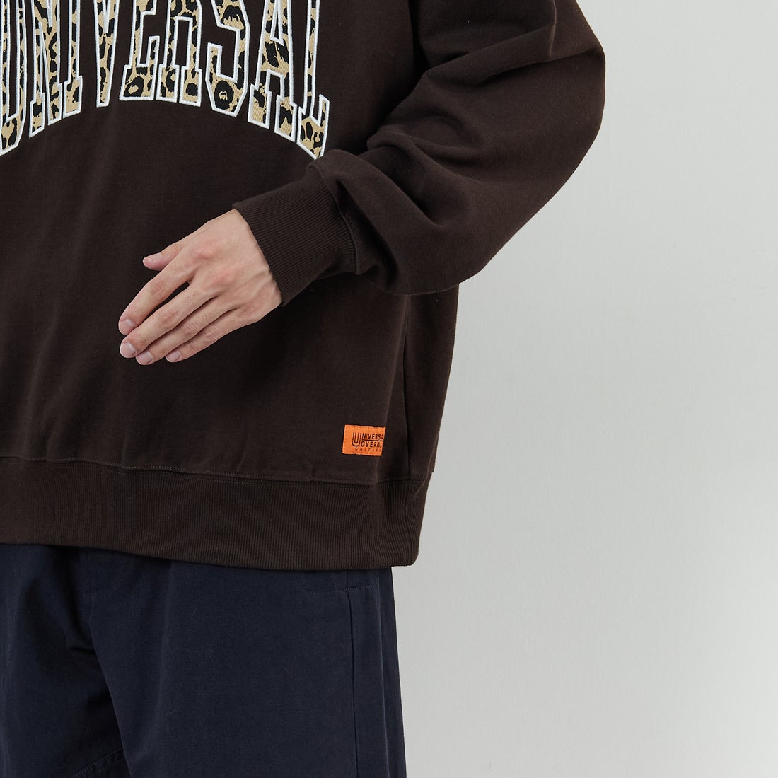 UNIVERSAL OVERALL [ユニバーサルオーバーオール] 別注 カレッジロゴデザイン クルーネックスウェット [U2531228IN-JF] BROWN &&モデル身長：168cm 着用サイズ：M&&