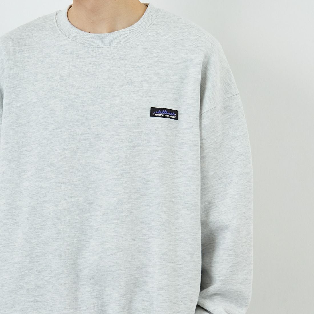 THOUSAND MILE [サウザンド マイル] 別注 ワンポイントロゴ クルーネックスウェット [TM252UK50510-JF] 11 LT.GRAY &&モデル身長：168cm 着用サイズ：M&&