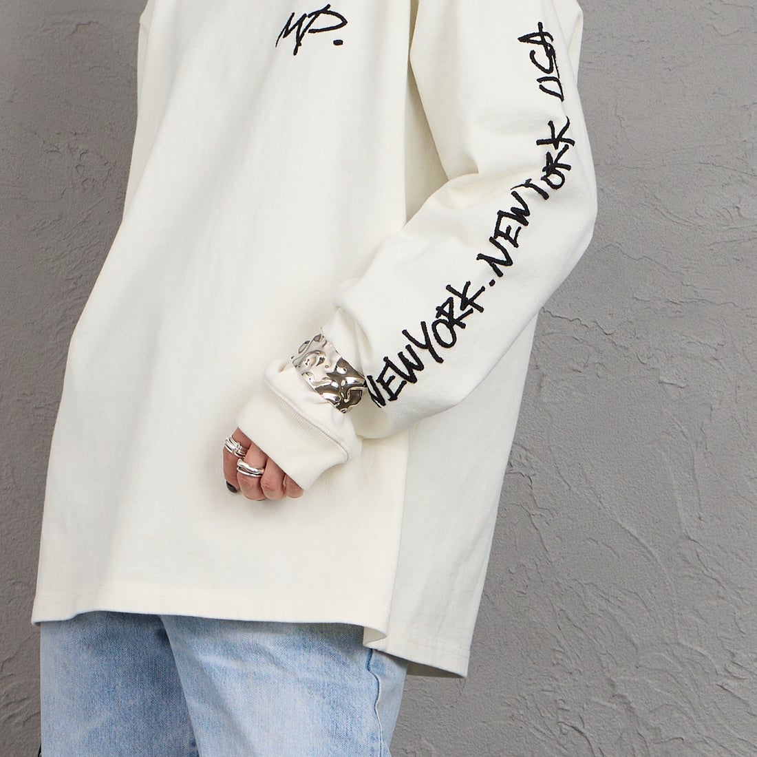 MANHATTAN PORTAGE [マンハッタンポーテージ] 別注 ピグメント染め 手書き風バックロゴ刺繍ロングスリーブTシャツ [26SSMP-IN84-JF] IVORY &&モデル身長：150cm 着用サイズ：S&&