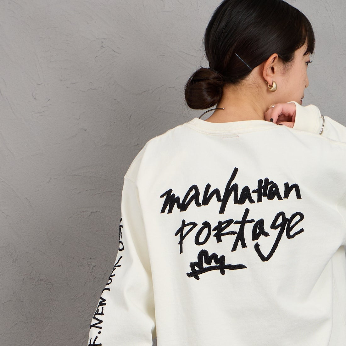 MANHATTAN PORTAGE [マンハッタンポーテージ] 別注 ピグメント染め 手書き風バックロゴ刺繍ロングスリーブTシャツ [26SSMP-IN84-JF] IVORY &&モデル身長：150cm 着用サイズ：S&&