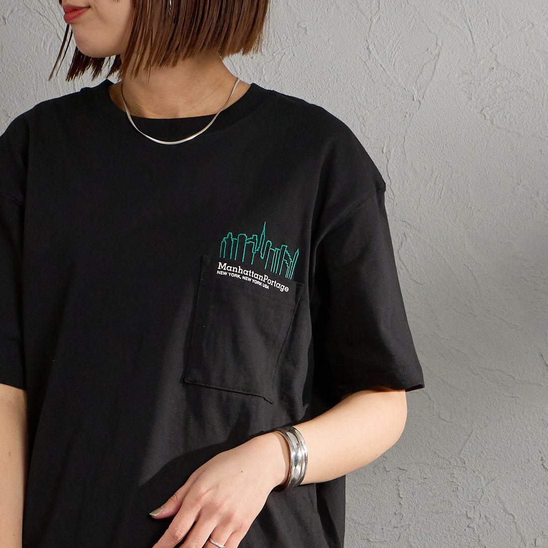 MANHATTAN PORTAGE [マンハッタンポーテージ] 別注 ポケット刺繍 バックプリントTシャツ [26SSMP-IN78-JF] BLACK &&モデル身長：159cm 着用サイズ：S&&