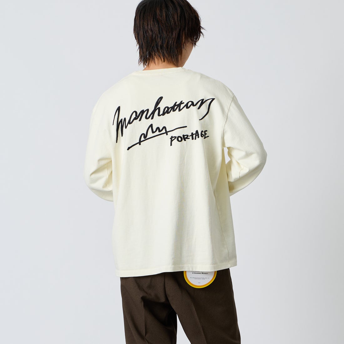 MANHATTAN PORTAGE [マンハッタンポーテージ] 別注 ピグメント染め 手描き風ロゴ刺繍ロングスリーブTシャツ [26FWMP-IN90-JF] IVORY &&モデル身長：177cm 着用サイズ：L&&