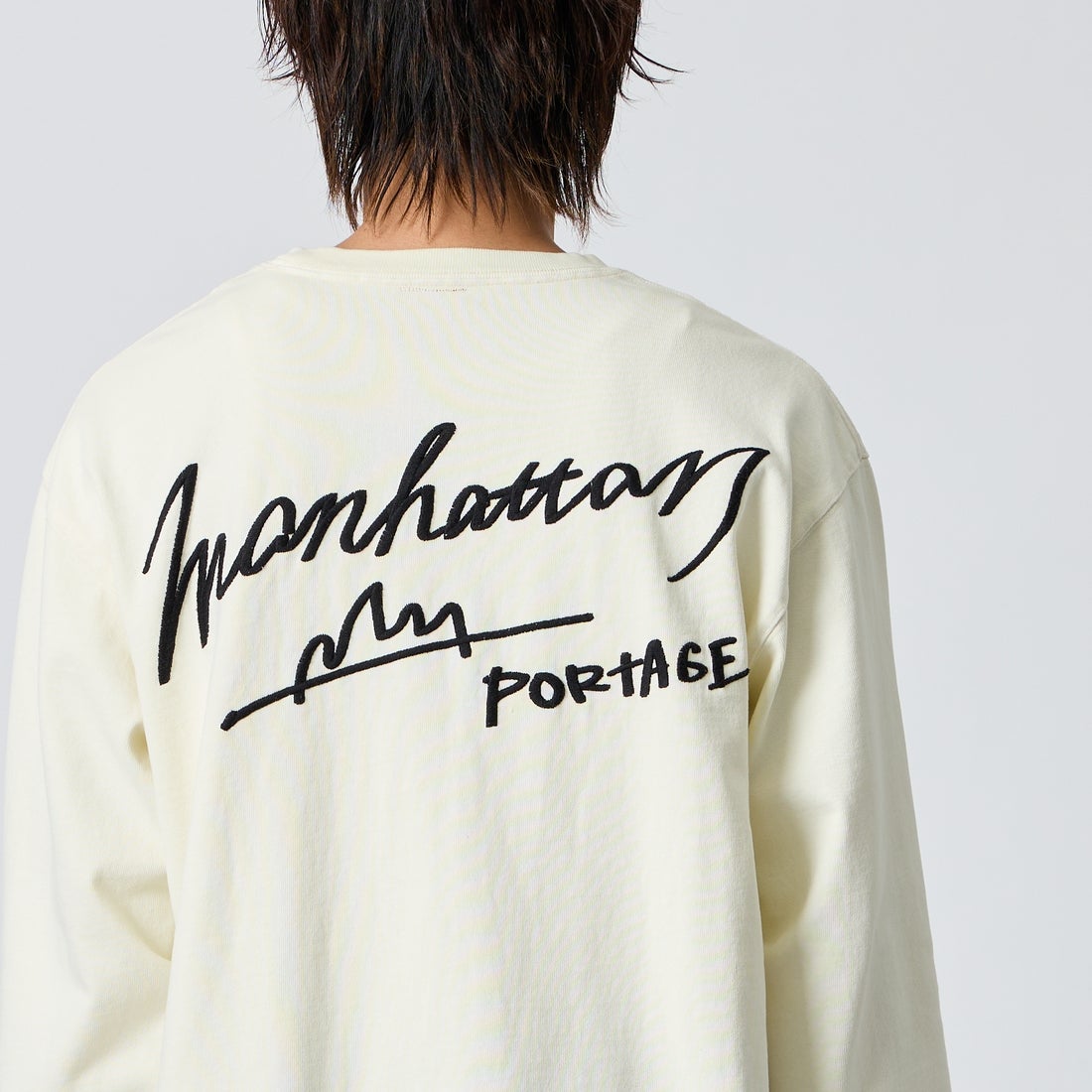 MANHATTAN PORTAGE [マンハッタンポーテージ] 別注 ピグメント染め 手描き風ロゴ刺繍ロングスリーブTシャツ [26FWMP-IN90-JF] IVORY &&モデル身長：177cm 着用サイズ：L&&