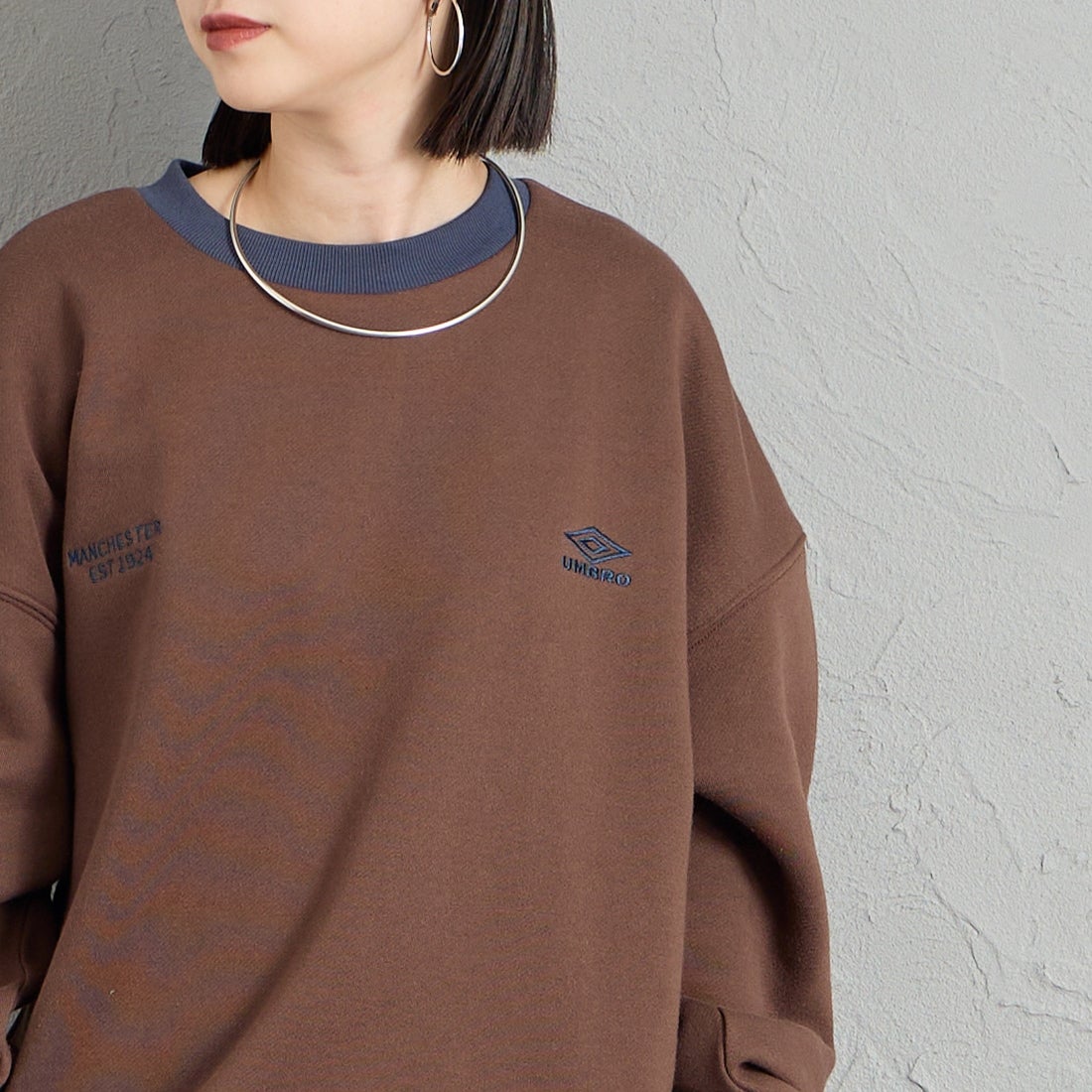 UMBRO [アンブロ] 別注 ワンポイントロゴ刺繍 クルーネックスウェット [201NK26AW-PO24-JF] D.BRN/NAVY &&モデル身長：150cm 着用サイズ：S&&